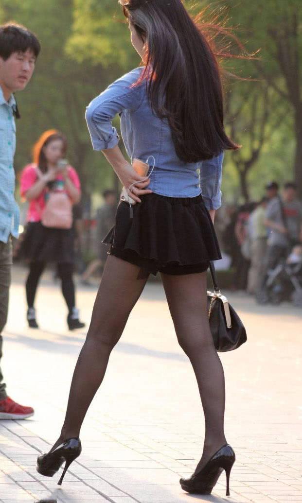 成熟少妇穿超短裙配黑丝袜高跟鞋，秀出一双纤细修长的美腿很有女